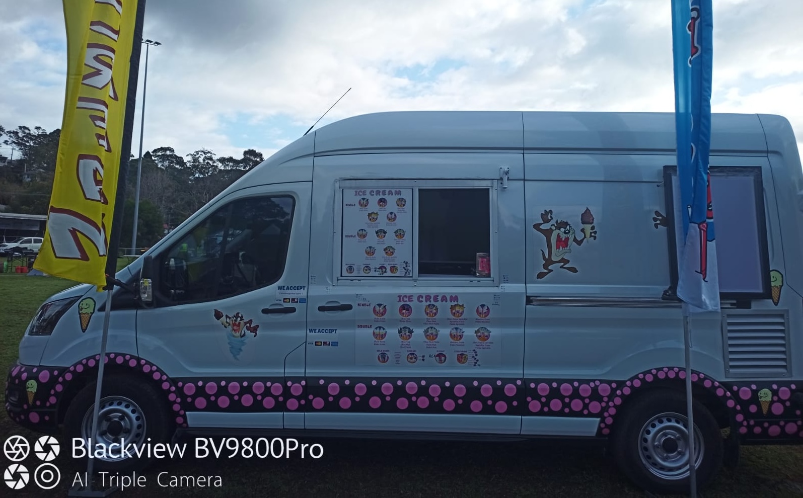 The Nice Cream Man van at an outdoor event, with flags